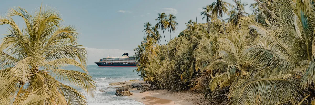EXPLORA III vor einer palmen-bewachsenen Insel in der Karibik.