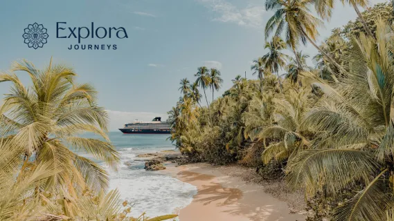EXPLORA II ankert an einem herrlichen Tag vor einer unbewohnten Karibikinsel mit Palmen und feinem Sandstrand.