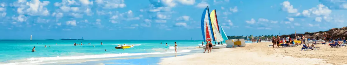 Surfer und Badegäste am weißen Strand von Varadero auf Kuba.