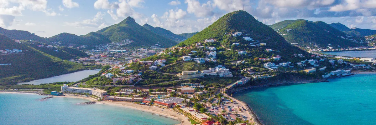 Karibik Ein Panoramabild der karibische Insel St. Maarten mit beeindruckenden Bergen und klarem Wasser.