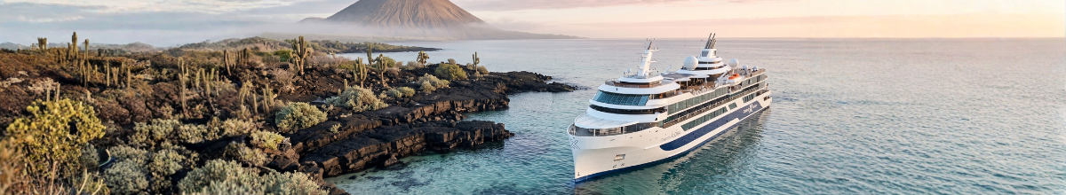 Celebrity Flora in einer Bucht der Galapagos-Inseln vor Lavaküste, Kakteen und Vulkankegel.