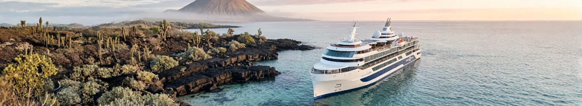 Celebrity Flora in einer Bucht der Galapagos-Inseln vor Lavaküste, Kakteen und Vulkankegel.
