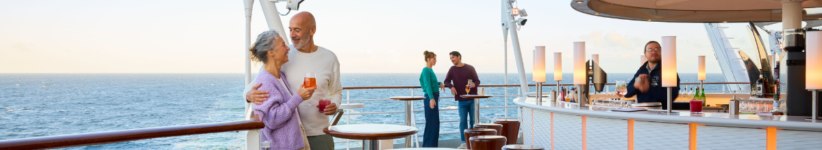 Paar genießt Drinks an der Ocean Bar auf AIDAluna mit Blick auf das Meer.