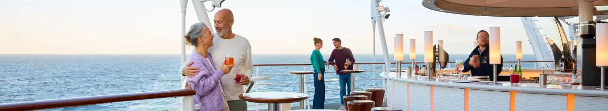 Paar genießt Drinks an der Ocean Bar auf AIDAluna mit Blick auf das Meer.