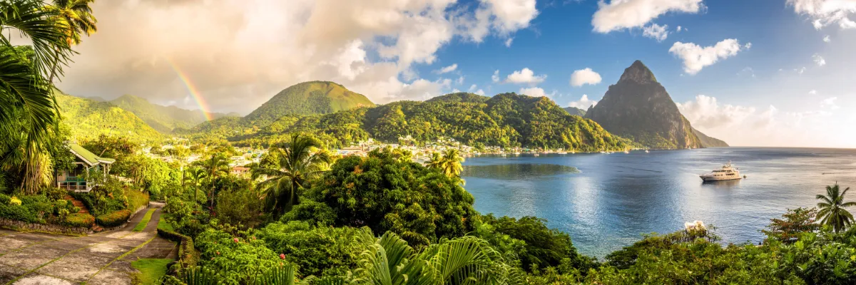 Blick auf die majestätischen Pitons und einen Regenbogen über der tropischen Küste von St. Lucia.