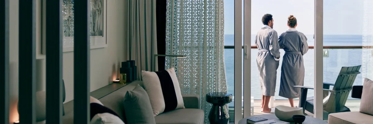 Ein Pärchen steht auf dem Balkon Ihrer Edge Villa auf einem Schiff von Celebrity-Cruises. Damit haben Sie Zugang zum exklusiven The Retreat.