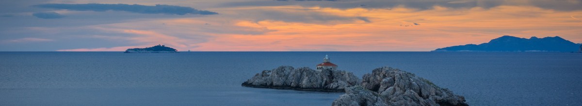 Ein sanfter Sonnenuntergang Bei Dubrovnik in Kroatien. Eine kleine, felsige Insel liegt im weiten Ozean.