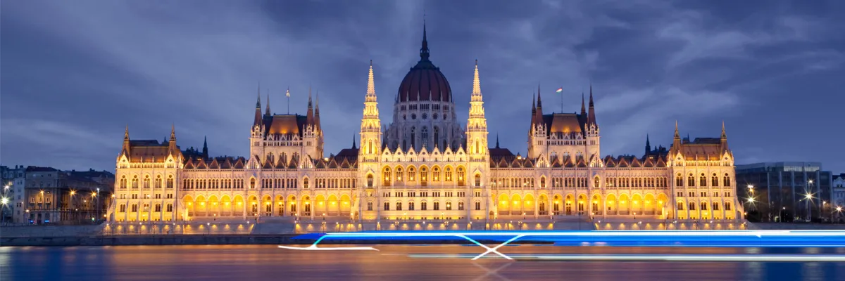Inklusivleistungen auf Celebrity Flusskreuzfahrten Die Umrisse eines neuen Celebrity Flussschiffes leuchten vor dem Parlament in Budapest.