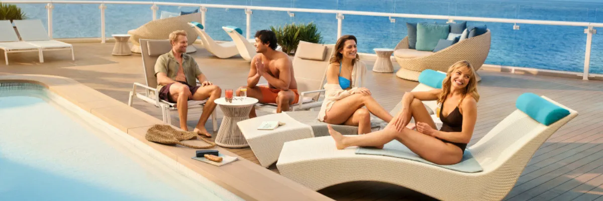 All Inclusive Kreuzfahrt mit TUI Cruises/Mein Schiff Vier Personen genießen Getränke in Sonnenliegen am Pool der X-Lounge auf einem Mein Schiff.
