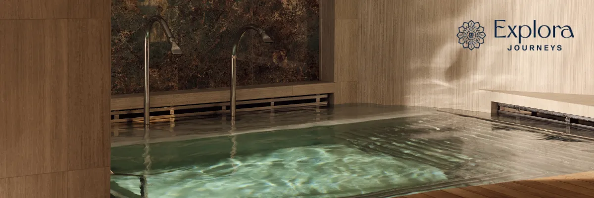 Ein Pool inn luxuriösem Ambiente im Wellnessbereich eines Explora Journeys Schiffes.
