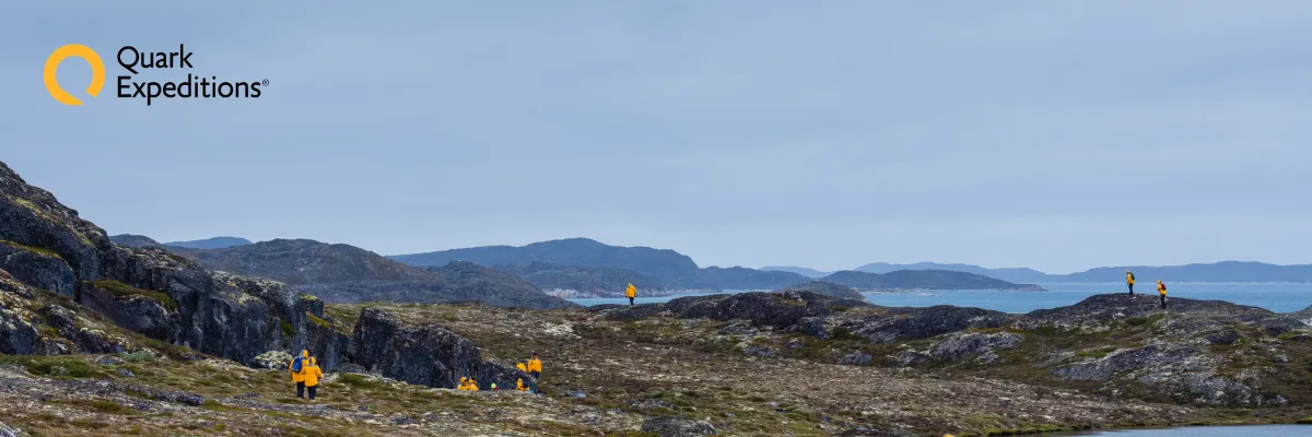 Expeditionskreuzfahrt mit Quark Expeditions Wanderer in gelben Parkas von Quark Expeditions erkunden die Tundra in Qeqertaq auf Grönland.
