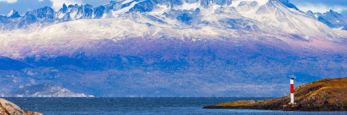 Lange Reisen Costa Frübucher 2027 2028 Ein Leuchtturm bei Ushuaia, Argentinien. Im Hintergrund erstrecken sich interessante Wolken.