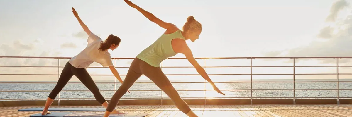 Yoga an Deck der Luxusflotte Zwei Damen die entspannt in der Morgensonne auf Deck Yoga machen.