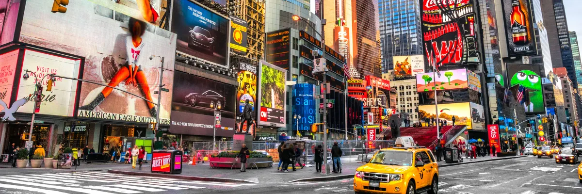 Cunard The New Yorker: Pulsierendes Leben am Times Square in Manhattan Blick auf den belebten Times Square in New York City mit leuchtenden Reklametafeln und gelben Taxis im Rahmen des Hotelaufenthalts der Cunard Transatlantik-Reise.