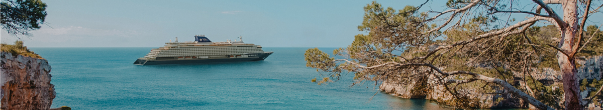 EXPLORA I im Mittelmeer zwischen felsigen Küsten an einem sommerlichen Tag.