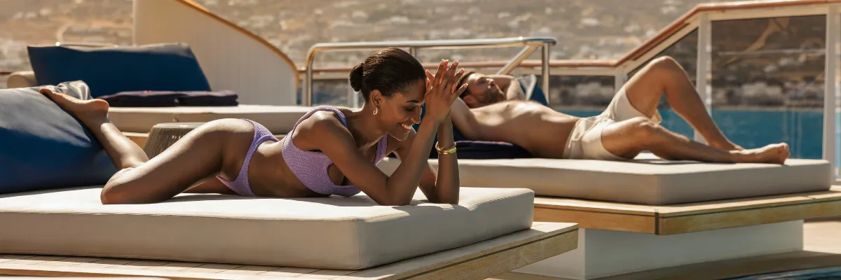 Gäste entspannen auf luxuriösen Daybeds auf dem weitläufigen Sonnendeck der EXPLORA VI.