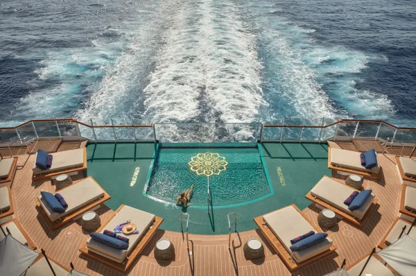 Blick von oben auf den Infinity-Pool am Heck der EXPLORA VI mit Daybeds und Blick auf die Kielschleppe.
