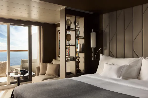 Ocean Terrace Suite an Bord der EXPLORA VI mit Kingsize-Bett, Loungebereich und privater Meerblick-Terrasse.