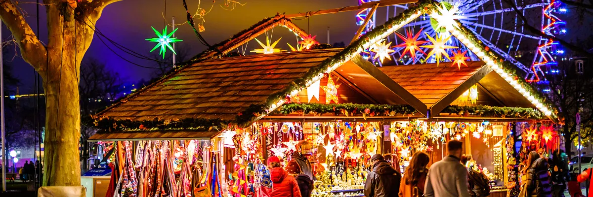 AMADEUS Festtagsreisen 2027 – Weihnachtsmärkte und Lichterglanz entlang der Donau Festlich beleuchteter Weihnachtsmarkt mit Riesenrad während einer AMADEUS Donau-Flusskreuzfahrt 2027.