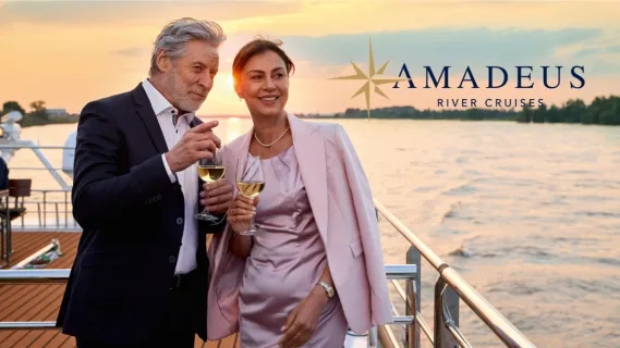 Elegantes Paar genießt Wein bei Sonnenuntergang auf dem Sonnendeck einer AMADEUS Flusskreuzfahrt 2027.
