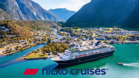 Das klassische Kreuzfahrtschiff VASCO DA GAMA von nicko cruises vor einer spektakulären Fjordkulisse mit Bergpanorama und Küstenort.