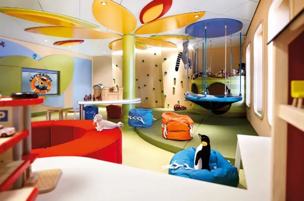 Ein Kids Club auf dem Schiff Europa 2 in bunten Farben – mit Spielzeugen wie ein Pinguin und ein Walross.