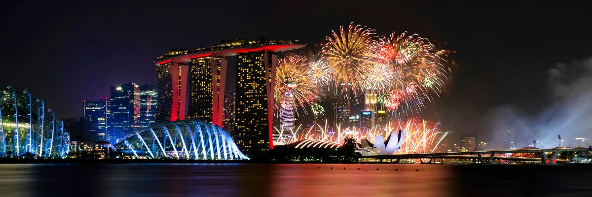 Farbenprächtiges Feuerwerk am nächtlich beleuchteten Marina Bay Sands Hotel in Singapur.