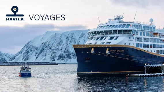 Küstenschiff Havila Castor vor schneebedeckter Fjordkulisse in Norwegen Das moderne Hybridschiff Havila Castor von Havila Voyages liegt im winterlichen Fjordhafen vor schneebedeckten Bergen.