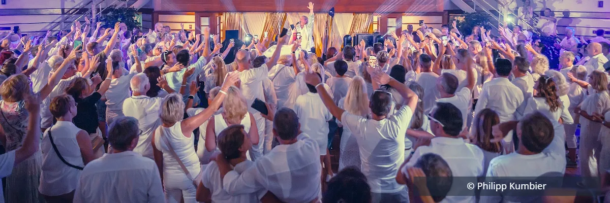 Die beliebte White Night gehört auch 2027 zu den Höhepunkten der Schlagerseereise Weiß gekleidete Schlagerfans feiern während der White Night an Bord.
