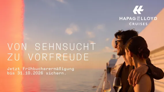 Zwei Gäste genießen bei Sonnenuntergang an Bord eines Schiffes von Hapag-Lloyd Cruises mit Champagner den Blick über das Meer – Kampagne Von Sehnsucht zu Vorfreude mit Frühbucherermäßigung bis 31. Oktober 2026.