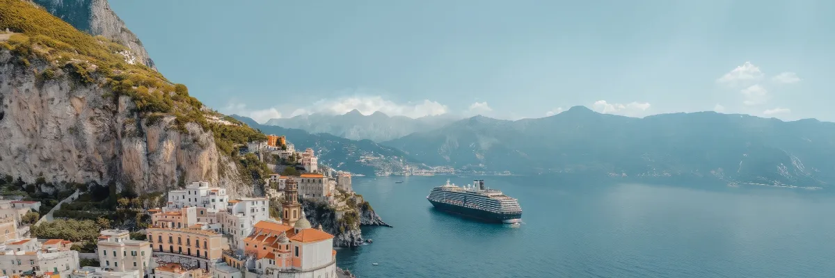 Explora Journeys – Exklusive Seereisen im Mittelmeer mit bis zu 40 % Ersparnis Explora Journeys Luxusschiff vor der malerischen Steilküste und den bunten Häusern der Amalfiküste.
