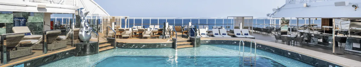 Pool auf der MSC Seashore mit Liegestühlen.