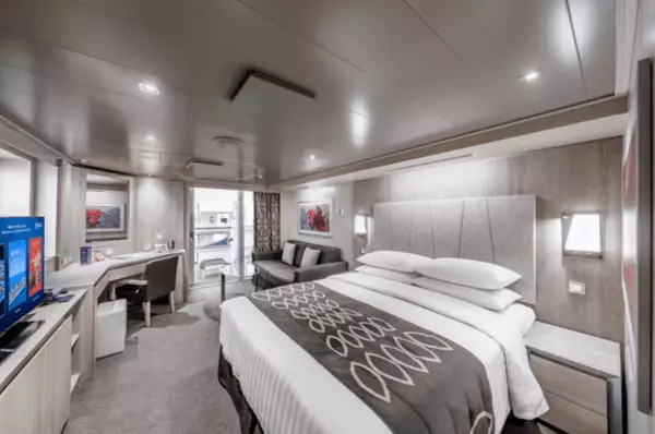 Blick in die Suite mit Doppelbett, TV und Balkon.