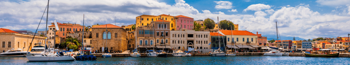 Segelboote im Hafen von Chania. Im Hintergrund die bunten Häuser der Stadt.