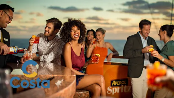 Gäste genießen Aperol Spritz an der Bar auf dem Außendeck eines Schiffs von Costa Kreuzfahrten während des Sonnenuntergangs.