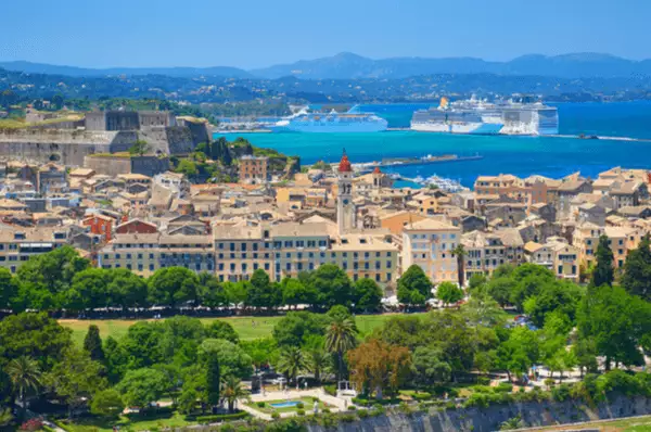 Blick über die Dächer von Korfu-Stadt auf den Kreuzfahrthafen, wo drei Schiffe an der Mole liegen