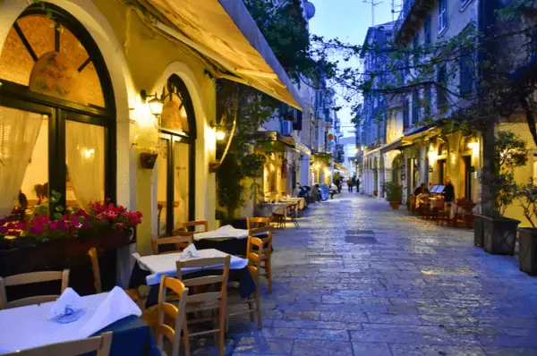 Wunderschöne Straße mit Restaurants auf Korfu bei Nacht.