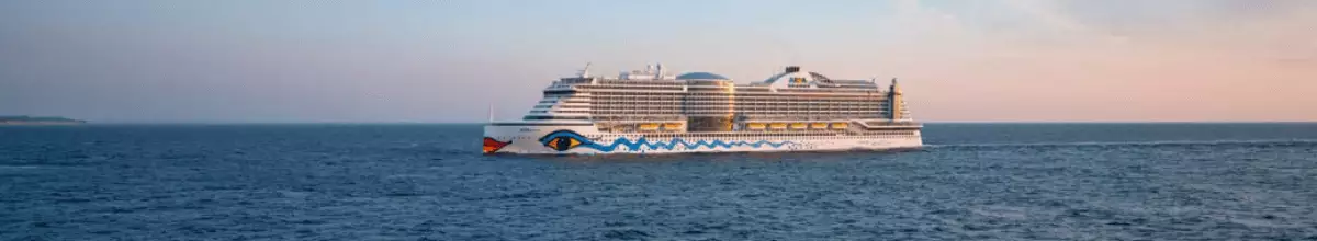 Seitenansicht von AIDAcosma vor rötlichem Himmel