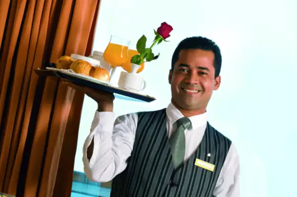 Ein Service-Mitarbeiter bringt Frühstück auf die Suite.