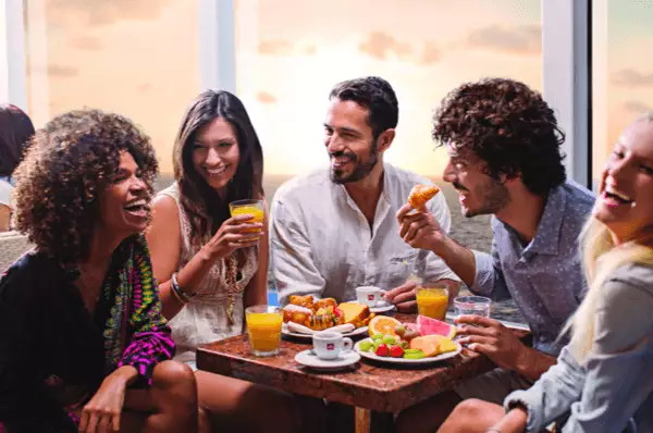 Eine Gruppe junger Leute genießt das Frühstück mit Meerblick auf einem Costa-Schiff. Mit dem Costa Tarif My Cruise sichern Sie sich leckere Verpflegung zu jeder Tageszeit.