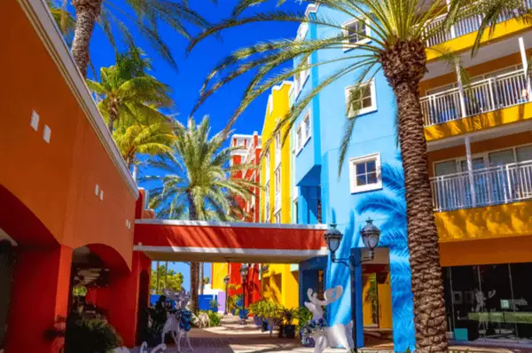 Kunterbunte Straße in Willemstad Straße mit Häusern in leuchtenden Farben und Palmen in Willemstad auf Curaçao.