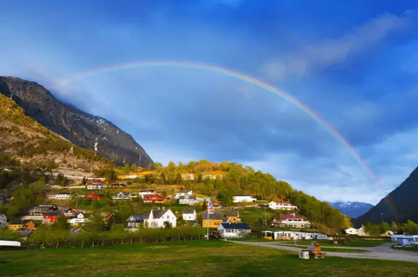 Regenbogen im Sonnenschein über den Häusern von Eidfjord
