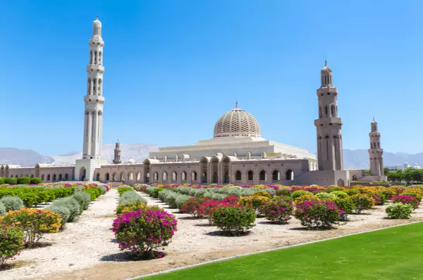 Bunte Büsche blühen vor der weißen Sultan Qabus Moschee in Muscat.