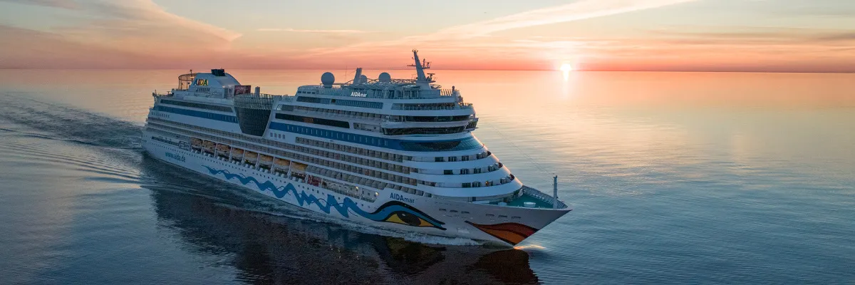 Die AIDAmar auf dem Ozean bei Sonnenuntergang.