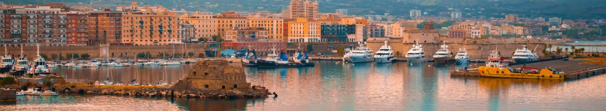 Panorama der Hafenstadt Civitavecchia mit historischen Festungsmauern und Booten am Kai.
