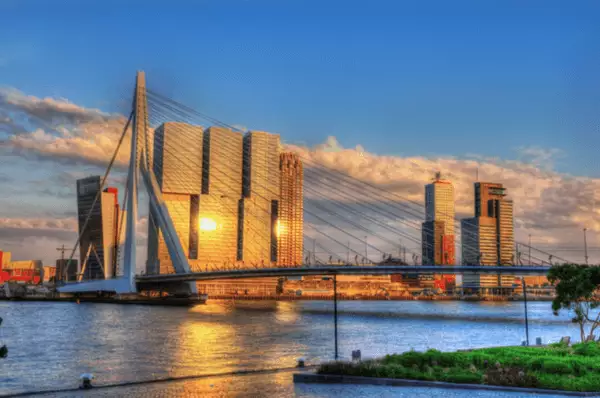 Rotterdam im Sonnenuntergang An den Fassaden der Hochhäuser an der Erasmusbrücke spiegelt sich die untergehende Sonne.