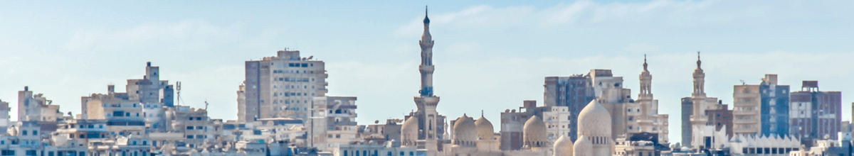 Blick vom Hafen auf Dächer von vielen Gebäuden mit unterschiedlichen Baustilen in Alexandria