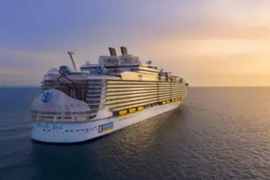 Rückansicht des größten Kreuzfahrtschiffs der Welt, der wundervollen Wonder of the Seas auf hoher See im Sonnenuntergang.