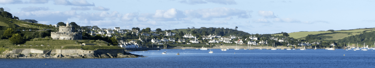 Bucht mit dunkelblauem Wasser und einer Aussicht auf eine alte Burg mit Blick auf Falmouth im Hintergrund.