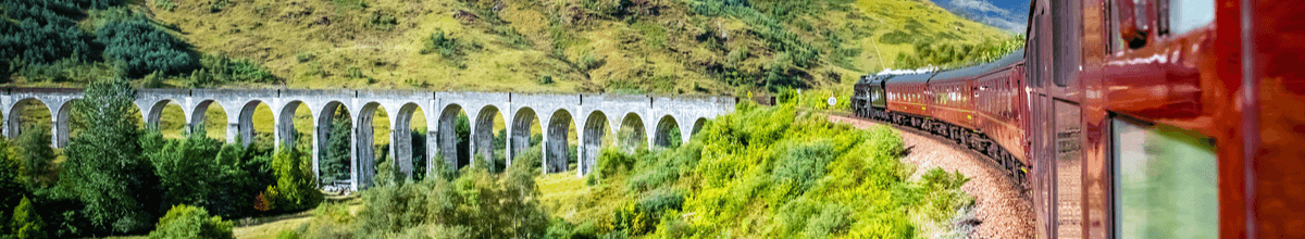 Glenfinnan Railway in Schottland bei Fort Williams mit historischem Viadukt und saftigem grünen Gras.